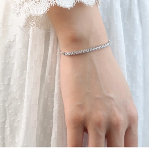 Primer plano de una pulsera tenis ajustable de plata con circonitas en la muñeca