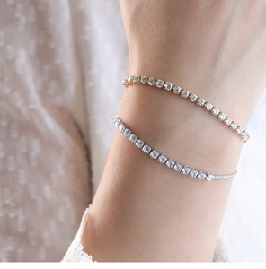 Vista detallada de pulseras tennis de oro y plata con circonitas en una muñeca