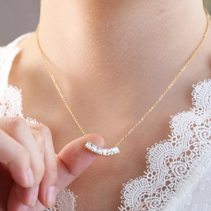 Elegante conjunto de collar tennis dorado con circonitas rectangulares en un modelo