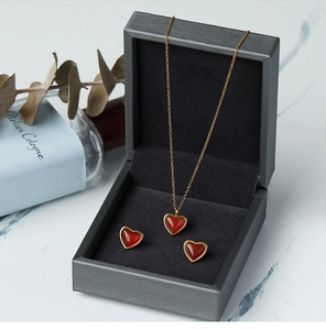 Conjunto de collar y pendientes de corazón rojo en un estuche de joyería carbón