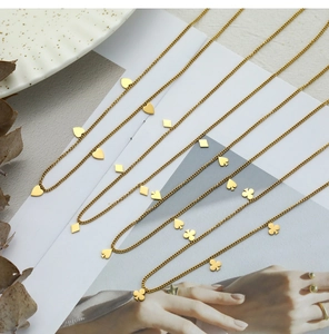Vista de detalle de los colgantes de cartas de póker bañados en oro de 18K en cadenas