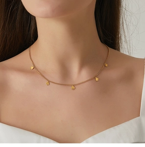 Primer plano de collar dorado con colgantes de picas en el cuello mostrando caída real