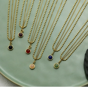 Detail of ball chain necklaces with round natural stone pendants in six various colors