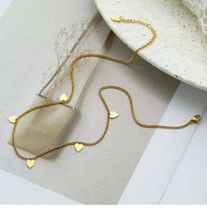 Vista de detalle del collar chapado en oro con colgantes de corazón en forma de S