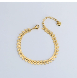 Detail von 18K vergoldetem Titanstahl-Armband mit Blattmotiven und Herzanhänger