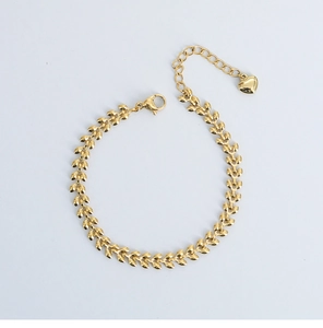 Detail eines 18K vergoldeten Armbands mit Ährenmuster, Karabinerverschluss und Herzanhänger