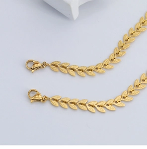 Nahaufnahme des 18K vergoldeten Titanarmbands mit geprägtem Weizenblatt und Textur