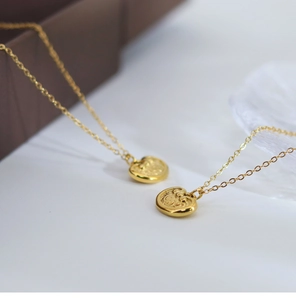 Macro detail of golden longevity lock necklace with traditional clouds pattern engraving