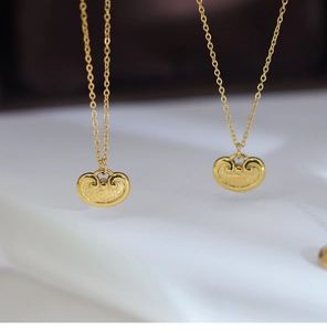 Macro shot of golden ruyi lock pendant with intricate cloud patterns on silk