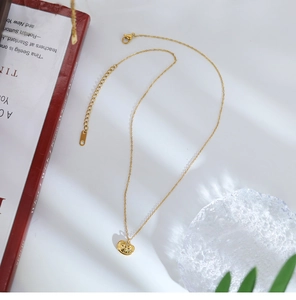 Close-up of golden Ruyi lock pendant with traditional carvings on a red book backdrop