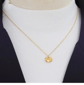 Detail showing vintage Chinese lock pendant with cloud patterns on a gold chain