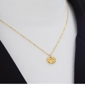 Macro shot of a vintage gold longevity lock pendant with traditional cloud patterns