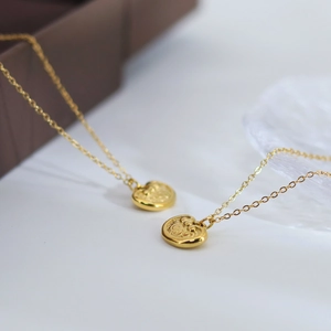 Retro golden longevity lock necklace with heart relief patterns on a jewelry box