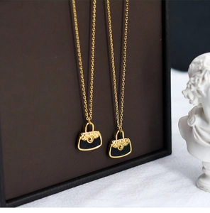 Detail of 18K gold-plated titanium chain with quilted black PU bag charm pendant