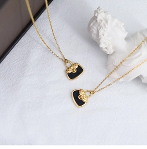 Macro shot of 18K gold plated necklace with miniature black quilted purse pendant detail