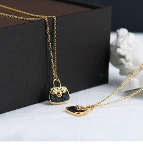 Macro shot of 18K gold plated necklace with quilted black PU leather bag pendant
