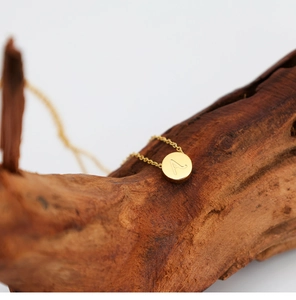 Detalle del collar de acero inoxidable chapado en oro de 18K con la letra A en el colgante