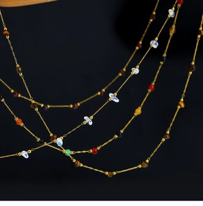 Macro detail of Bohemian multilayer necklace with amethyst and 18K gold plated beads