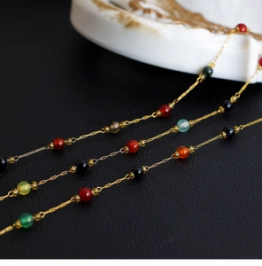 Detail view of 18K gold-plated necklace with irregular amethyst and colorful gemstones