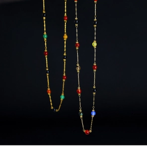 Detail of 18K gold plated chain necklace with colorful amethyst and tiger eye beads