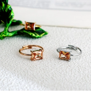 Macro detail of adjustable square-cut champagne zircon rings in rose gold and silver finishes