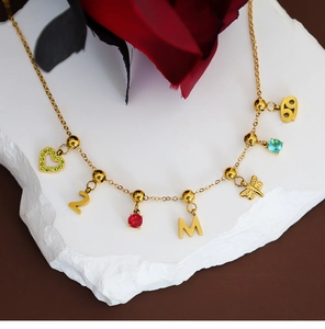 Golden multi-pendant necklace with colorful crystals and charms on a stone platform