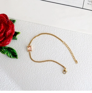 Detail of thin gold-plated chain bracelet with champagne zircon stone and adjustable clasp