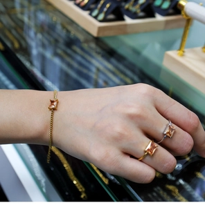 Detailed view of champagne rectangle zircon rings and matching bracelet set in gold finish