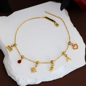 Gold stainless steel bracelet with heart charms and assorted geometric pendants