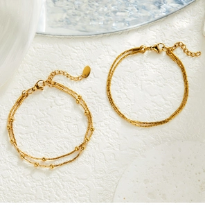 Close-up of double-layer snake chain bracelet with metal beads in 18K gold finish