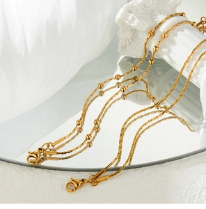 Macro detail of gold-plated double-layer snake chain bracelet with elegant beads