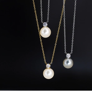 Detailed view of grey pearl pendants with zircon in gold and silver plating