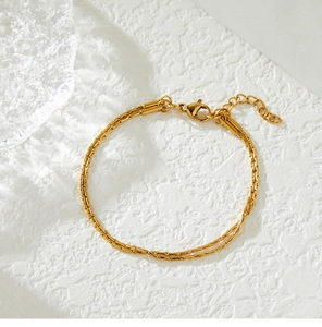 Detailed view of gold plated double-layer snake chain bracelet with lobster clasp