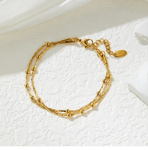 Close-up of 18K gold-plated double-layer snake chain bracelet with K18 tag and lobster clasp
