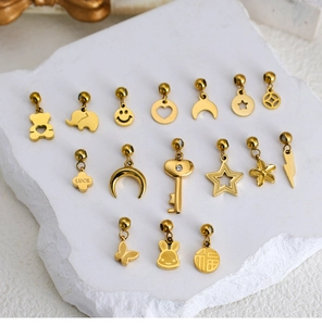 Detailed close-up of mixed gold stainless steel pendants on a stone surface