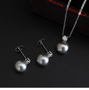 Detailed view of silver jewelry set with grey pearls and sparkling zircon accents