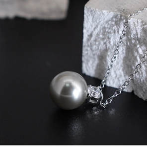 Macro shot of grey pearl pendant necklace with sparkling cubic zirconia on a silver chain