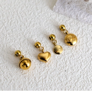 Macro shot of gold stainless steel charms with Lucky and Love you engravings