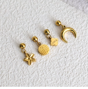 Macro detail of gold stainless steel DIY pendants with Luck clover and moon charms