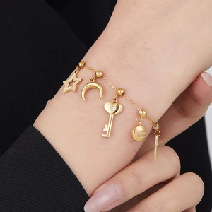 Golden stainless steel bracelet with moon, star, and heart charms on a stylish wrist