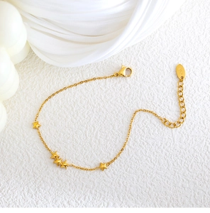 Close-up of 18K gold plated minimalist bracelet featuring five-pointed star charms