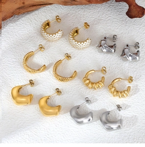 Detailed close-up of gold-plated C-shaped twisted rope and lava textured earrings