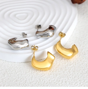 Close-up of gold and silver C-shaped chunky drop earrings with irregular wavy texture