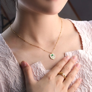 Tropical monstera leaf pendant necklace and ring set with green gemstone in gold finish
