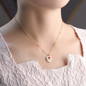 Tropical monstera leaf necklace in gold plated titanium steel with red gemstone