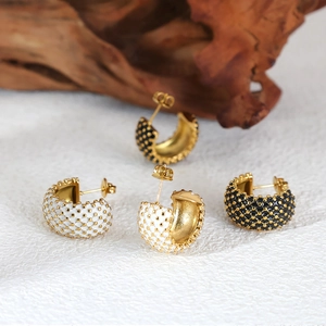 Gold-plated C-shaped earrings with black and white enamel polka dot texture on a stone base