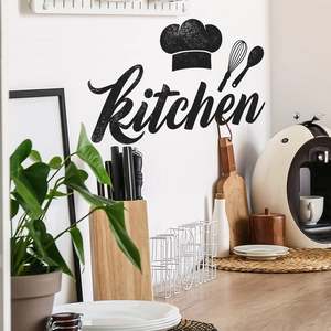 Kitchen wall decal featuring chef hat icons and artistic lettering on a white kitchen wall