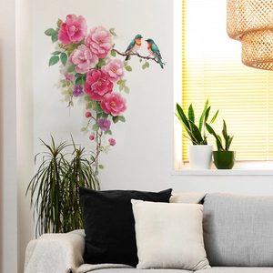 Floral wall decal with birds and pink roses over a gray sofa in a modern white room