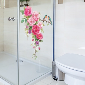 Floral wall decal with pink roses and colorful birds on a glass shower door