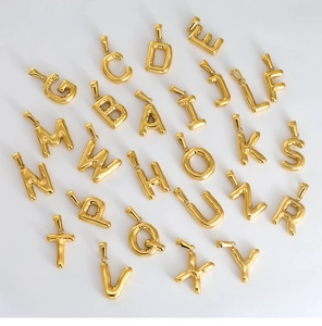 Detailed macro view of 26 3D golden balloon-style alphabet pendants with a metallic sheen